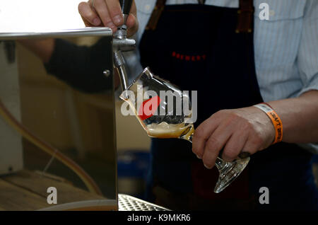 Les mains du barman de la bière à couler à partir d'un tour de la bière. Banque D'Images