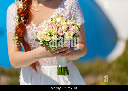Belle Mariée rousse avec un bouquet de fleurs Banque D'Images