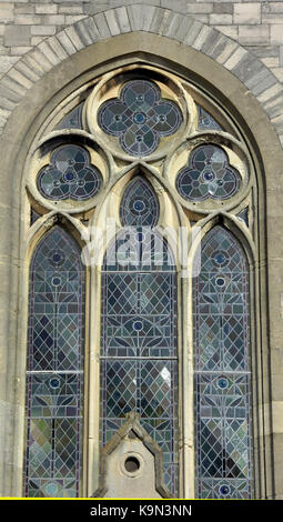 Une grande église ou cathédrale chapelle fenêtre avec feux au plomb et vitraux décoratifs dans un cadre d'inspiration gothique remplages de pierre. Banque D'Images