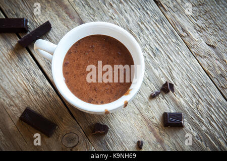 Du chocolat chaud et de morceaux de chocolat sur fond de bois rustique. chocolat chaud maison verre pour l'automne et d'hiver. Banque D'Images