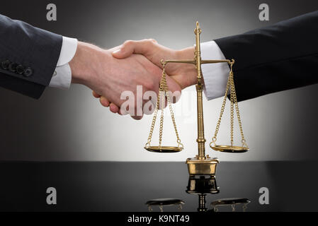 Close-up of two businessman shaking hands en face d'échelle Banque D'Images