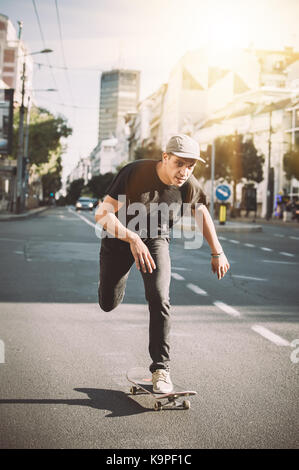 Patineur professionnel équitation skate dans les rues par les voitures et le trafic lourd Banque D'Images