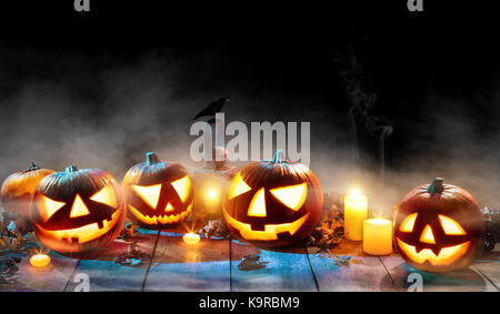 Spooky Halloween pumpkins sur des planches sur fond noir. célébration thème, copyspace pour le texte. Banque D'Images