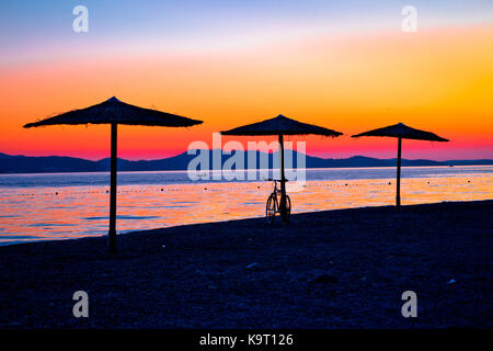 Plage et parasols colorés sur le coucher du soleil, mer adriatique, Zadar, Dalmatie Région de la Croatie Banque D'Images