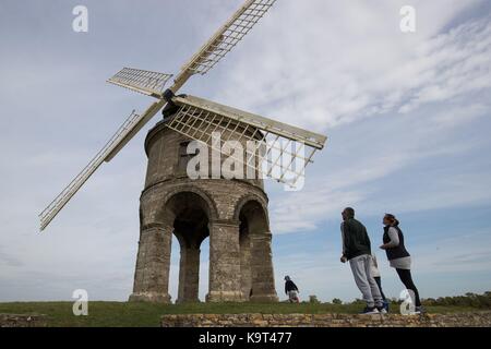 Une famille prenez le temps de considérer le moulin à vent de Chesterton, un 17e siècle en pierre moulin tour cylindrique qui est de catégorie 1 dans la liste, à l'extérieur du village de Chesterton, Warwickshire. Banque D'Images