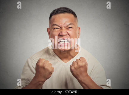 Closeup portrait portrait en colère contre l'homme d'âge moyen, la bouche ouverte jusqu'poing dans l'air des cris agressifs mur gris isolé. l'arrière-plan des droits négatifs emot Banque D'Images