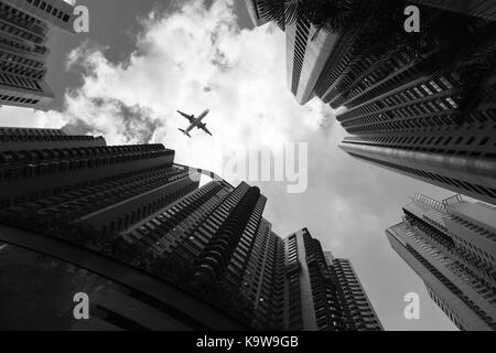 Paysage urbain avec passager avion survolant les gratte-ciel, les tours à bureaux de Hong Kong, noir et blanc Banque D'Images