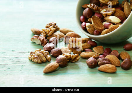 Mélanger les noix, amandes, noisettes, arachides, noix sur un fond de bois Banque D'Images