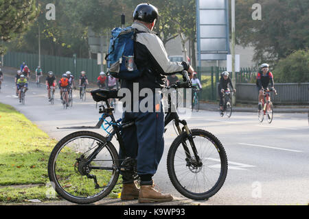 Birmingham, UK. 24 Septembre, 2017. 15 000 cyclistes participent à une route fermée de 100 milles cas de Birmingham et dans le contexte plus large des Midlands. Le trajet fait partie du conseil municipal de Birmingham's Cycle Stratégie de révolution - un plan à long terme pour encourager plus de vélo. Un cycliste attend patiemment une lacune dans le trafic pour traverser la route. Peter Lopeman/Alamy Live News Banque D'Images