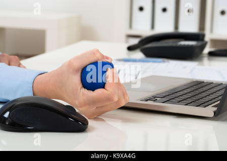 Close-up of woman squeezing stressball portable sur la main Banque D'Images