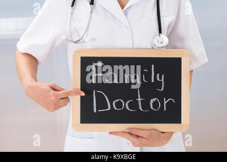 Close-up of female doctor montrant l'ardoise ardoise avec texte médecin de famille Banque D'Images