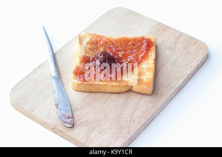 Délicieux toasts avec confiture de fraises sur une plaque de bois et isolé sur fond blanc Banque D'Images