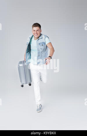 Jeune homme en chemise bleue avec suitcase Banque D'Images