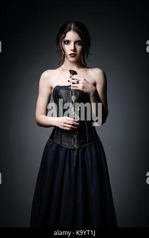 Portrait de belle goth girl holding a withered rose dans les mains Banque D'Images