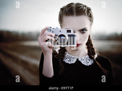 Belle jeune fille triste sur la photographie vintage caméra. closeup portrait en extérieur Banque D'Images