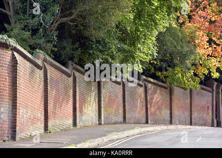 Un mur de brique sur un hilll et un coin à caterham, Surrey, avec les arbres d'automne qui pèsent sur le dessus. Banque D'Images