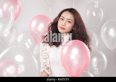 Jolie asiatique mode femme en robe blanche avec des ballons pastel Banque D'Images