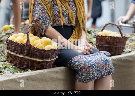 Asti, ITALIE - 10 septembre 2017 : femme vêtue de vêtements antiques porte pêche jaune baskets Banque D'Images