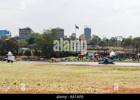 Les personnes bénéficiant de colporter des promenades en bateau ainsi que de s'asseoir près de Lake et à les regarder, Uhuru Park, Nairobi, Kenya, Afrique de l'Est Banque D'Images