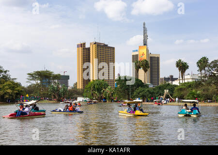 Les personnes bénéficiant de colporter des promenades en bateau ainsi que de s'asseoir près de Lake et à les regarder, Uhuru Park, Nairobi, Kenya, Afrique de l'Est Banque D'Images