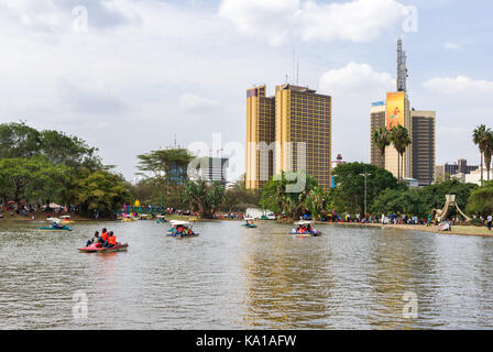 Les personnes bénéficiant de colporter des promenades en bateau ainsi que de s'asseoir près de Lake et à les regarder, Uhuru Park, Nairobi, Kenya, Afrique de l'Est Banque D'Images