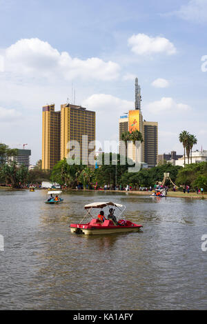 Les personnes bénéficiant de colporter des promenades en bateau ainsi que de s'asseoir près de Lake et à les regarder, Uhuru Park, Nairobi, Kenya, Afrique de l'Est Banque D'Images