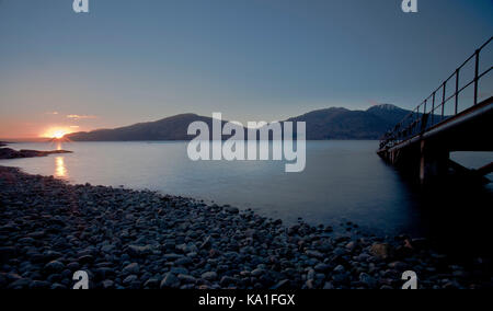 Coucher de soleil sur un lac près de glenelg dans les highlands écossais. l'île de Skye peut être voir sur le lac. Banque D'Images