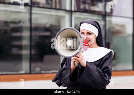 Surpris nun parlent de mégaphone à l'extérieur. Banque D'Images