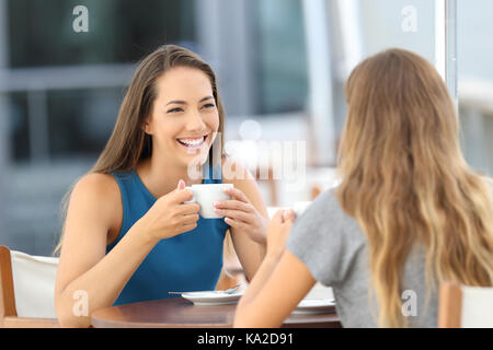 Deux amis heureux d'avoir une conversation informelle dans un bar terrasse Banque D'Images