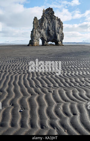La formation de Big Stone sur le sable volcanique foncé sur le fond du ciel bleu avec des nuages. il est hvitserkur durant la marée basse en Islande. verticale. Banque D'Images