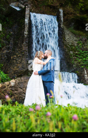 Bride and Groom kissing devant une cascade Banque D'Images