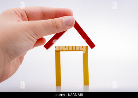 Hand holding pièces domino formant une forme de maison Banque D'Images