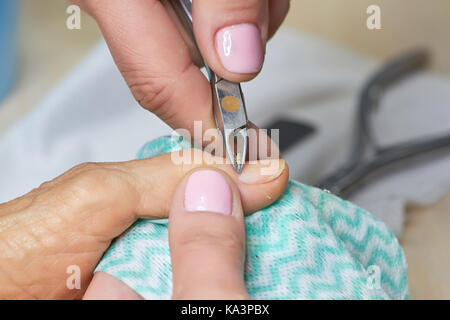 Esthéticienne au cuticule coupe gants à client. Boucher les cuticules de fraisage d'une femme âgée. manucure et soins de beauté spa manucure.. Banque D'Images