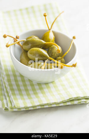 Petits fruits marinés caper sur table de cuisine. Banque D'Images