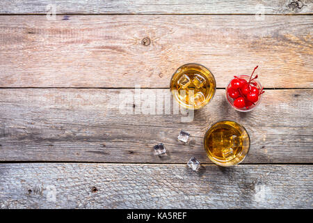 Whisky avec glace en glassesand cerise sur fond de bois rustique, vue supérieure avec copie espace Banque D'Images
