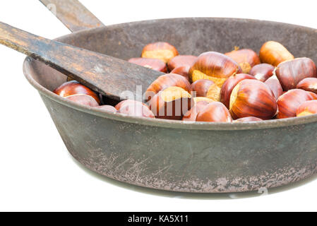 Châtaignes. Fruits d'automne caractéristique sur fond blanc. Châtaignes fraîches dans un vieux poêle avec des trous sur le fond Banque D'Images