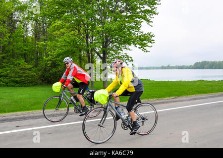 Deux cyclistes à vélo sur une route de campagne le long du lac Ontario, dans la région de l'Ontario, Canada. Banque D'Images