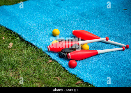 Juggling clubs et balles sont sur le tapis bleu close-up Banque D'Images