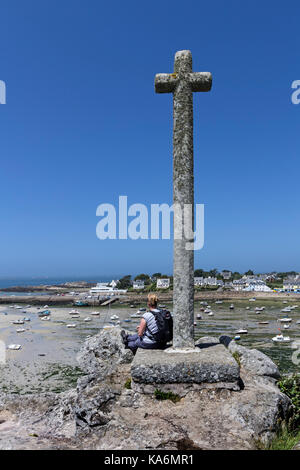 Randonneur admirant la vue de la Croix sur le promontoire, le Guilliguy Portsall Ploudalmezeau,,, finistere, Bretagne, France Banque D'Images