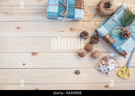 Vue de dessus du fond de noël sur planche en bois bleu avec le sapin, des cônes et des cadeaux faits à la main. copier l'espace. Banque D'Images