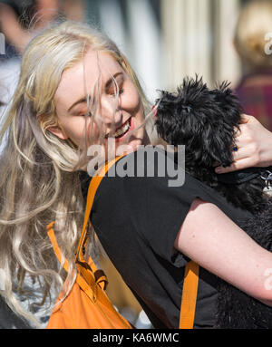 Jeune jolie femme saluant un chien c'est de lécher son visage. Banque D'Images
