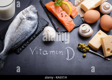 Table en ardoise noire avec des produits riches en vitamine D et les oméga 3. parole écrite la vitamine D de craie blanche. Banque D'Images