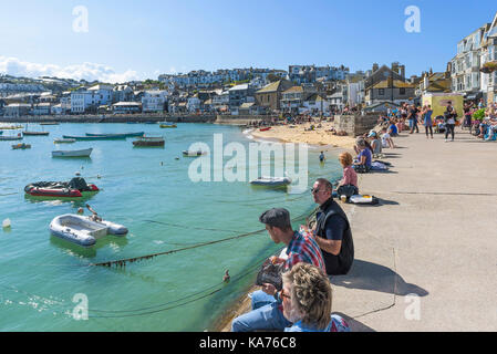 St Ives - Détente des vacanciers sur le quai au port de St Ives Cornwall. Banque D'Images