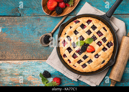 Tarte aux fruits maison traditionnelle dans une poêle, pâtisserie au four doux de la nourriture sur table en bois rustique, vue du dessus Banque D'Images