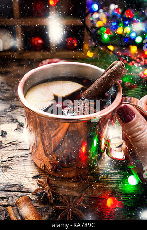 Vin chaud dans la tasse en cuivre avec des décorations de Noël sur la table en bois Banque D'Images