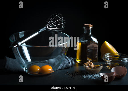 Jaunes dans un bol en verre, mélanger au fouet pour fouetter, l'huile d'olive l'horizontale Banque D'Images