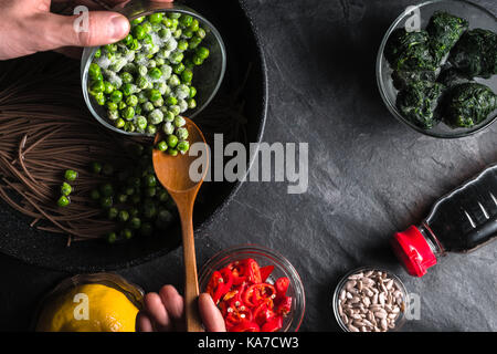 Nouilles de sarrasin dans une poêle, les pois congelés, citron, les graines de tournesol dans un bol l'horizontale Banque D'Images