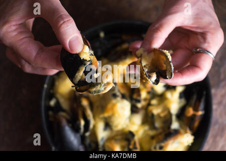 Femme les mains ouvertes les portes de moules à l'horizontale de la sauce au fromage Banque D'Images