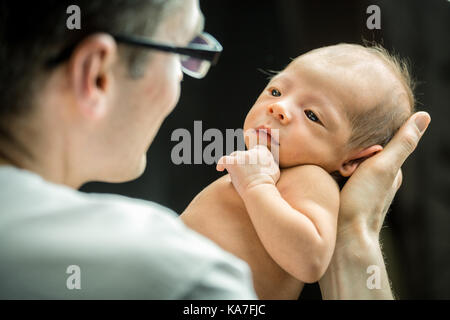 Happy father holding avec amour son fils âgé de 3 semaines Banque D'Images