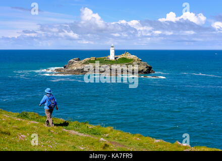 Femme randonnées sur route côtière au point de godrevy godrevy godrevy, phare de l'île, près de gwithian, Cornwall, Angleterre Banque D'Images